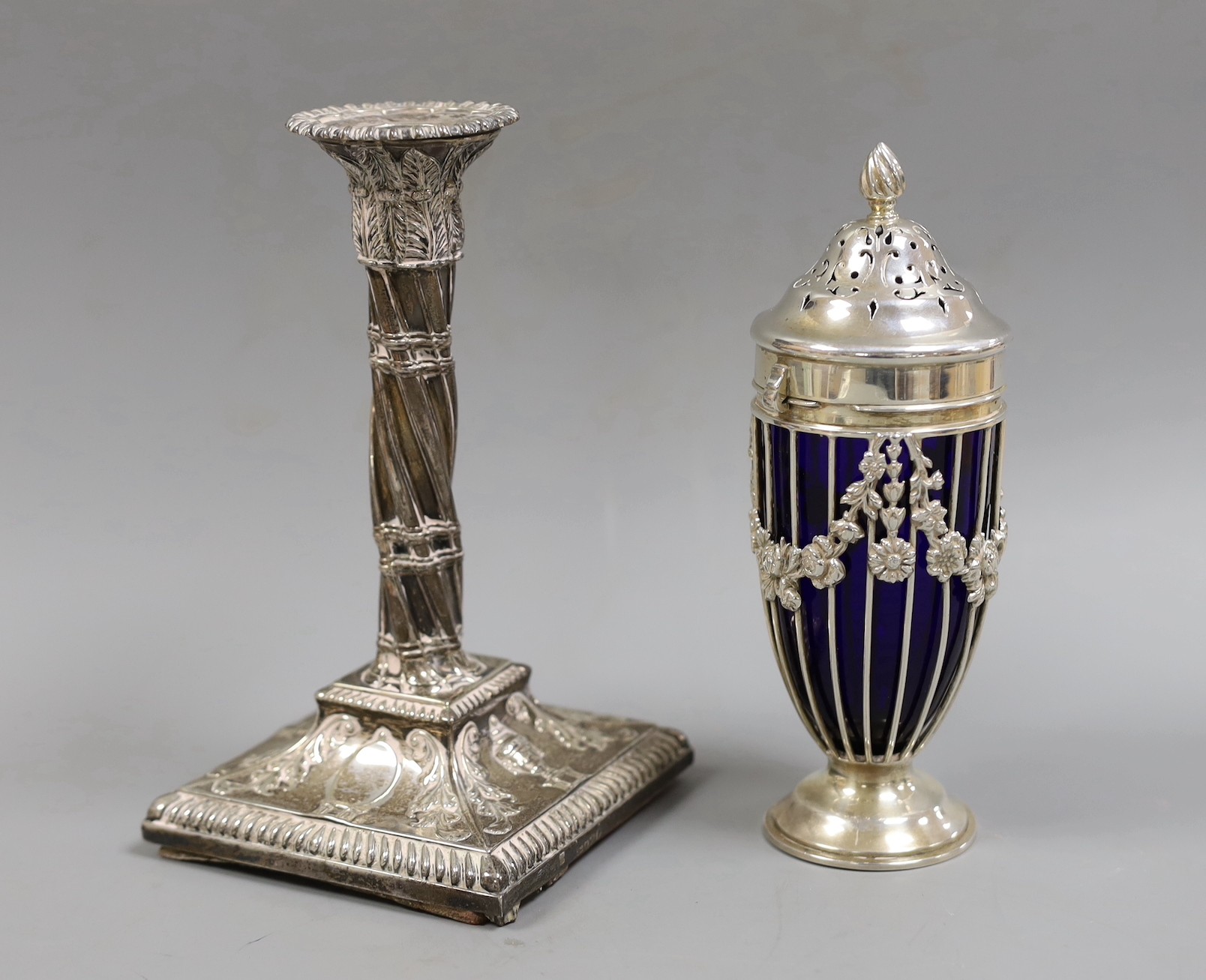An Edwardian pierced silver sifter, with blue glass liner, Haseler Brothers, London, 1904, 17.3cm and a single Victorian silver candlestick, weighted.